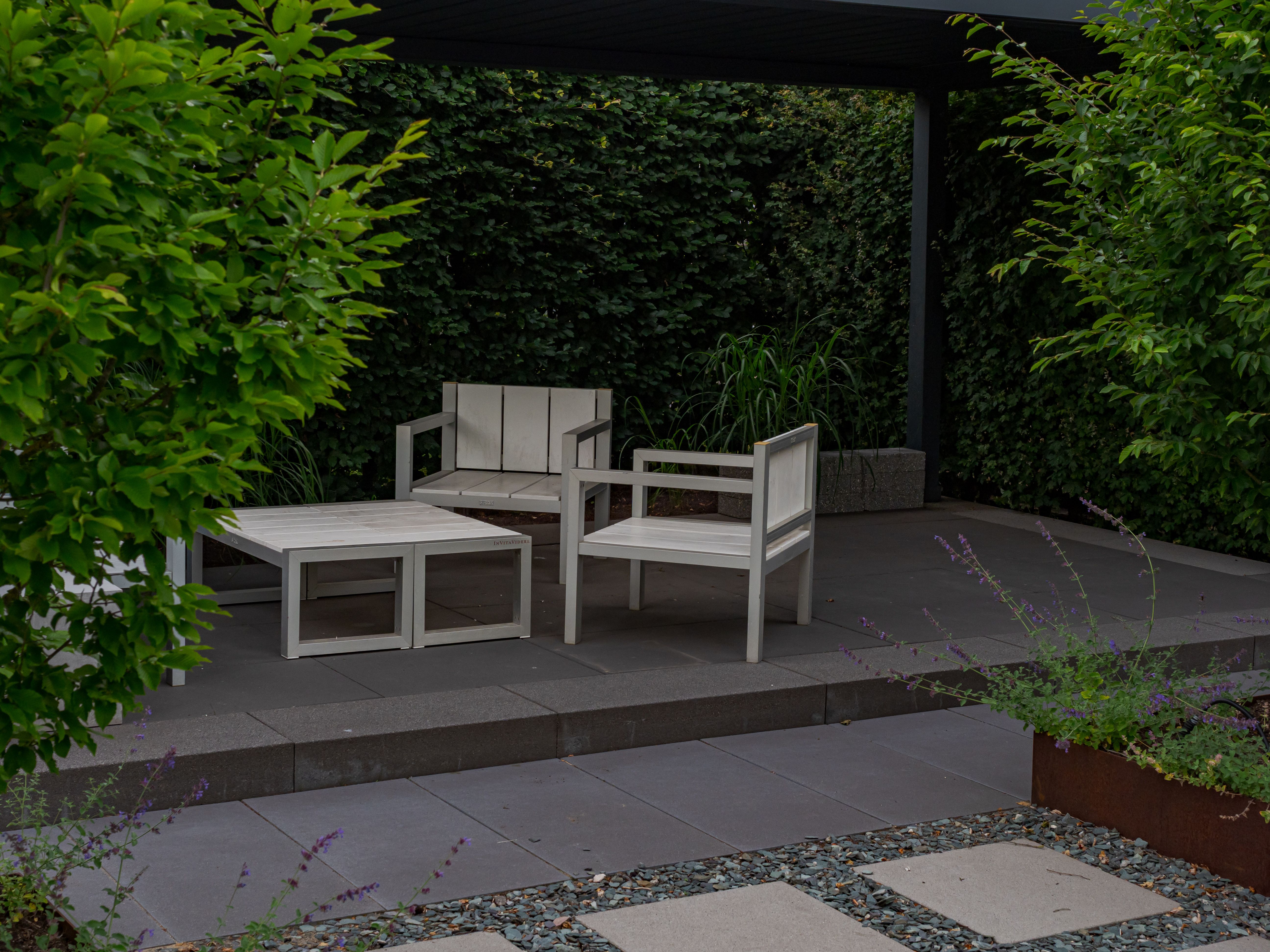 Minimalist wooden outdoor furniture in a lush garden setting